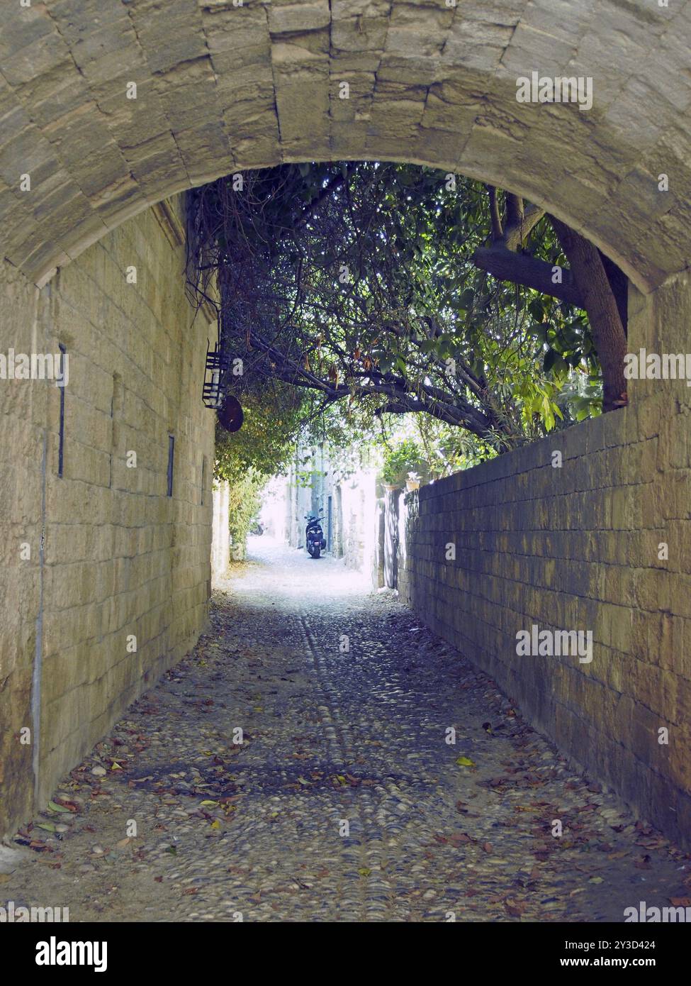 Typische ruhige Kopfsteinpflasterstraße in rhodos Stadt mit einem Steinbogen und alten Gebäuden Stockfoto