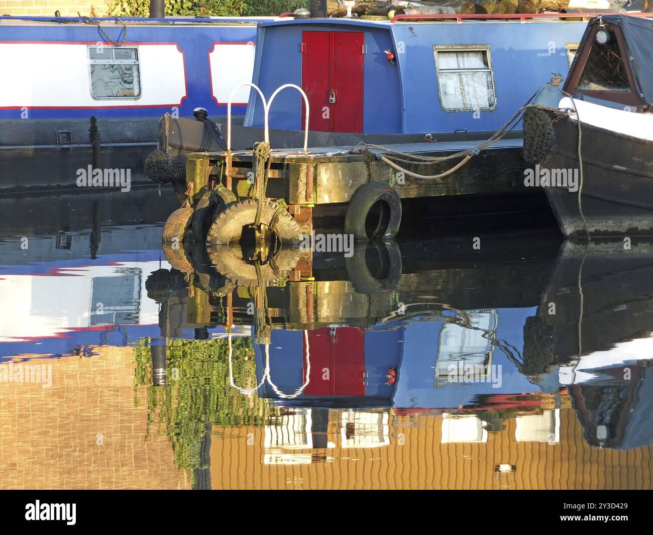 Alte schmale Boote und Lastkähne, die in Hausboote umgebaut wurden, die im Yachthafen im brighouse Basin in West yorkshire vertäut sind Stockfoto