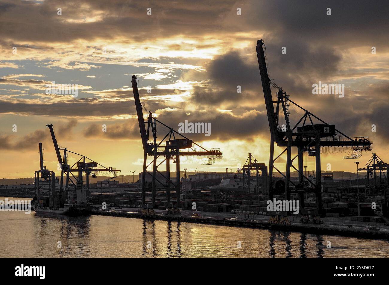 Industriehafen mit großen Kränen im Vordergrund und einem dramatischen Sonnenuntergang über dem Wasser, Göteborg, Ostsee, Schweden, Europa Stockfoto