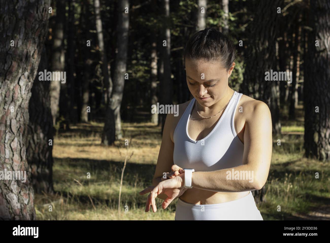 Junge Sportfrau, die den Stoppuhr für ihr Training ansieht Stockfoto