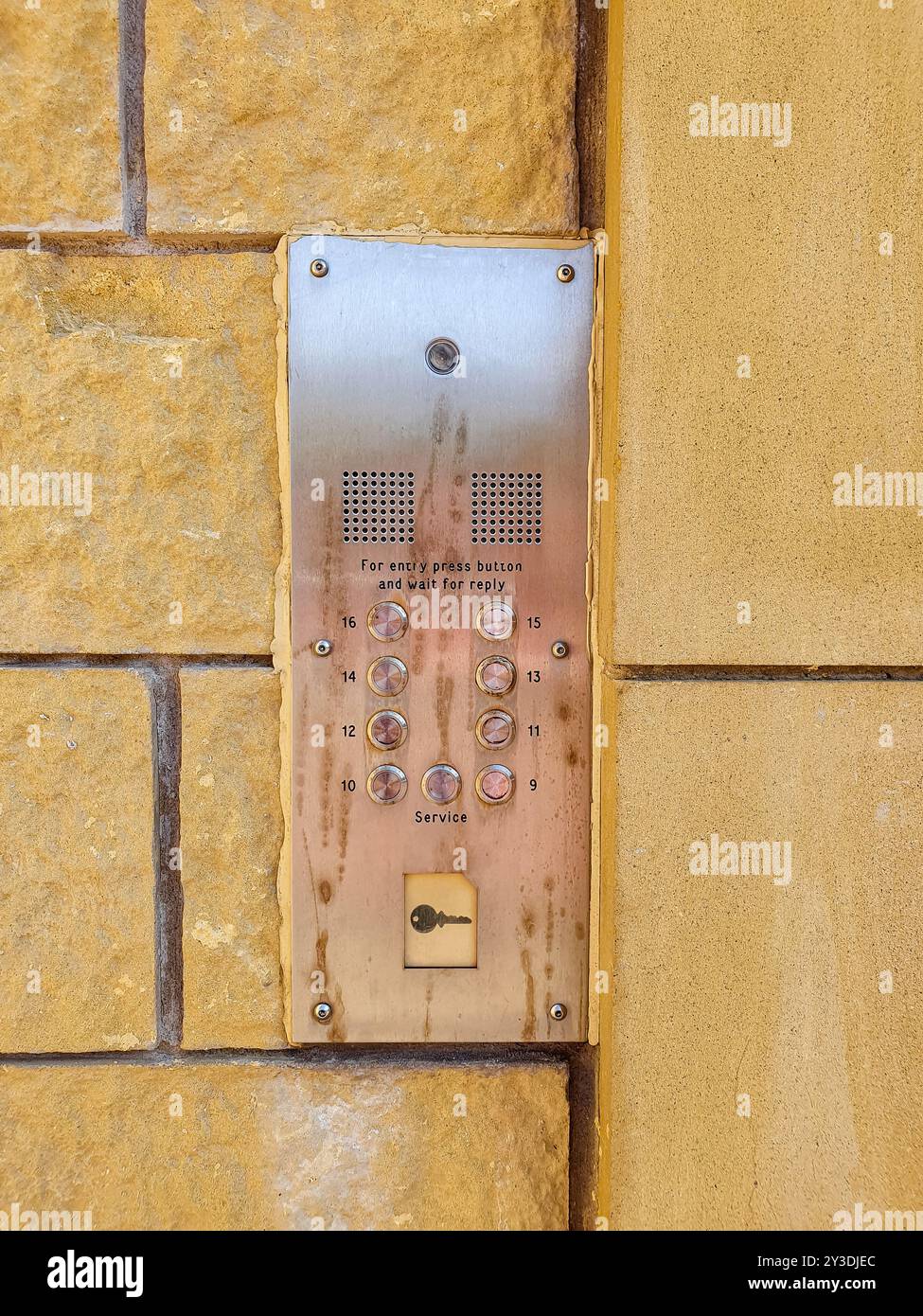 Die Platte ist aus Metall und an einer gelben Steinwand befestigt. Er verfügt über einen Sensor für die Schlüsselfernbedienung an der Unterseite, der die Eingabe der Schlüsselkarte oder des Schlüsselanhängers ermöglicht. Stockfoto