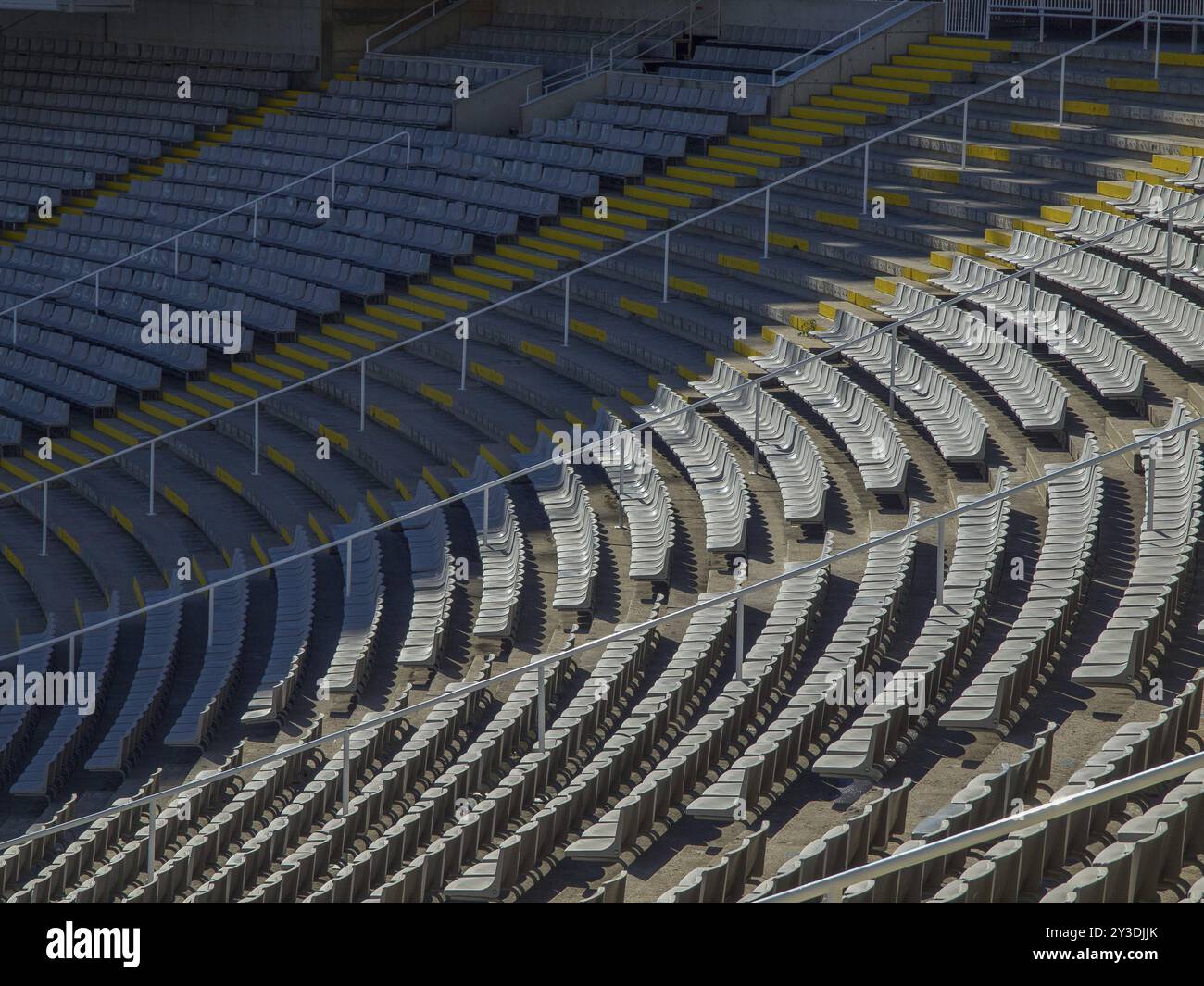 Leere Stadionstände mit mehrstufigen Sitzreihen und gelben Stufen in geometrischen Mustern, barcelona, mittelmeer, spanien Stockfoto