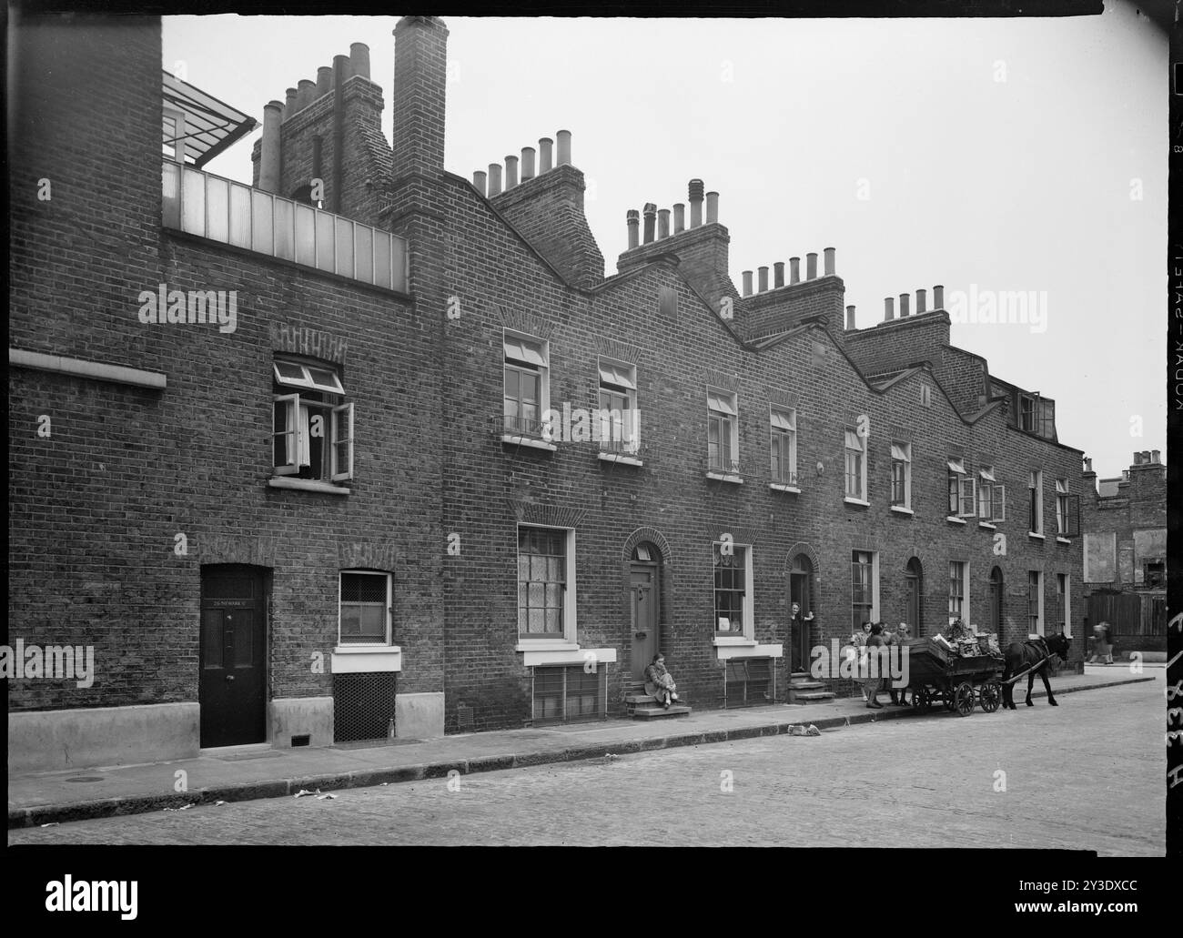 Turner Street, Stepney, Tower Hamlets, Greater London Authority, 1949. Nummern 56-64 Turner Street von der Kreuzung der Newark Street mit dem Eingang zur 26 Newark Street im Vordergrund und einem Pferdewagen, der weiter entlang der Straße steht. Nur die Häuser 26 Newark Street und 64 Turner Street sind noch erhalten. Stockfoto