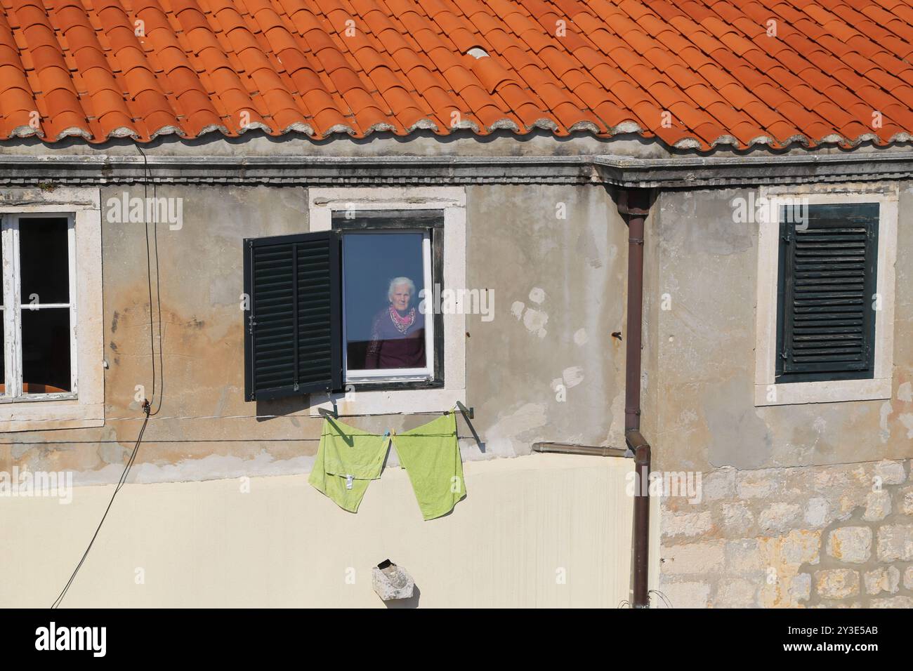 Dubrovnik, Kroatien, Altstadt, gekacheltes Dach eines Hauses, altes Steinarchitektur Gebäude mit einer dreieckigen Fassade mit Blick auf Reiseplätze, Fenster und W Stockfoto