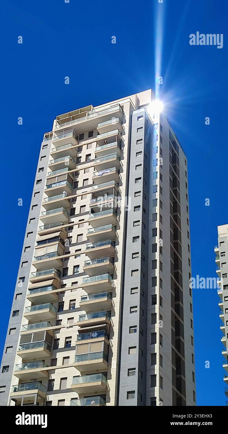 Bau eines grauen Hochhauses, Fenster Bürogebäude, Stadt Objekt, blauer Himmel. Hochwertige Fotos Stockfoto