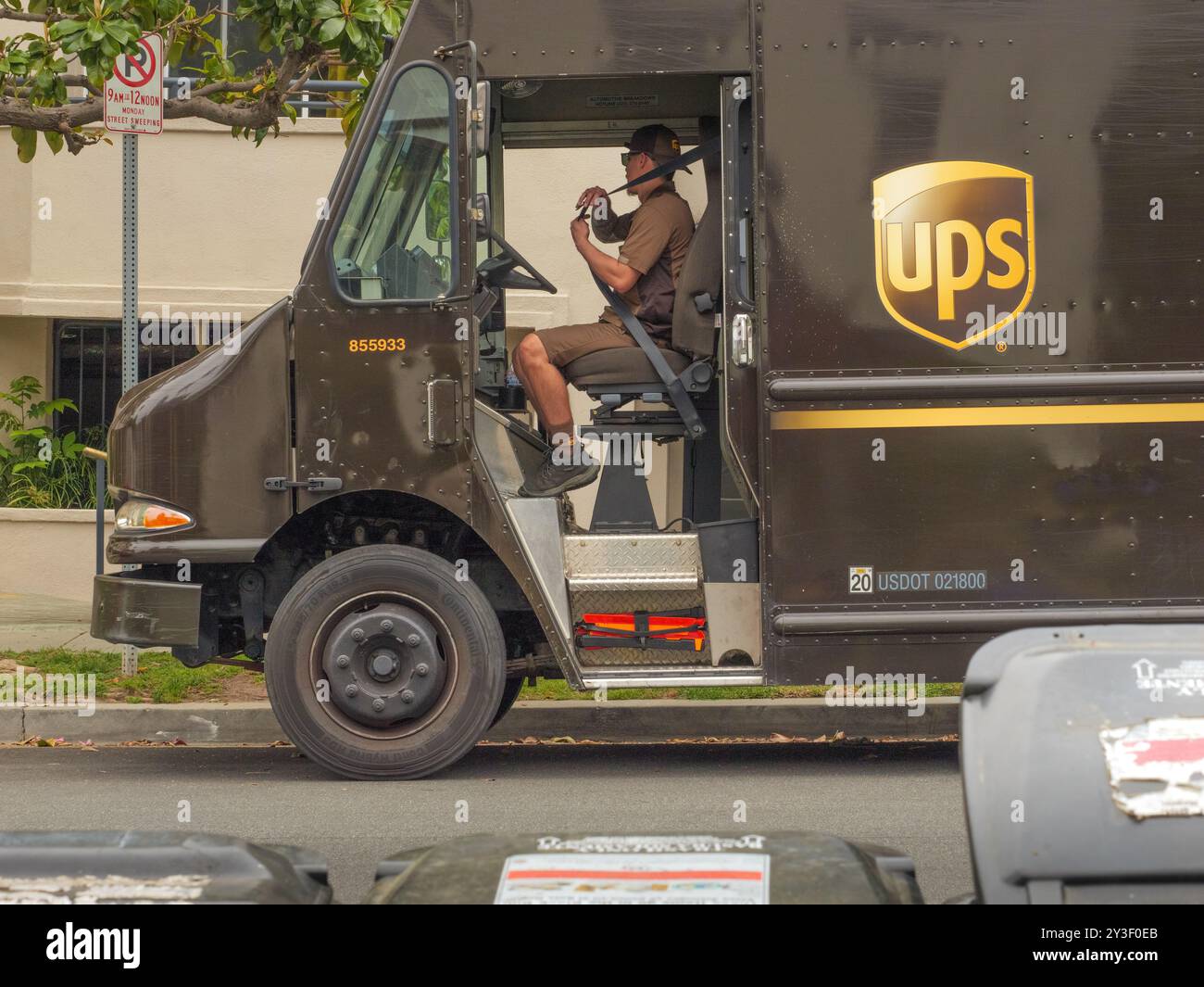 LOS ANGELES, CA - Mai 2024: UPS-Lieferwagen, der Pakete an ein Gebäude in einer Wohnstraße in West Hollywood, Kalifornien, liefert Stockfoto