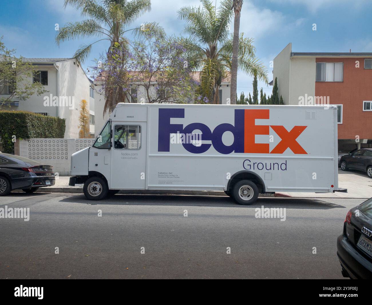 LOS ANGELES, CA - Mai 2024: FedEx-Lieferwagen, der Pakete an ein Gebäude in einer Wohnstraße in West Hollywood, Kalifornien, liefert Stockfoto