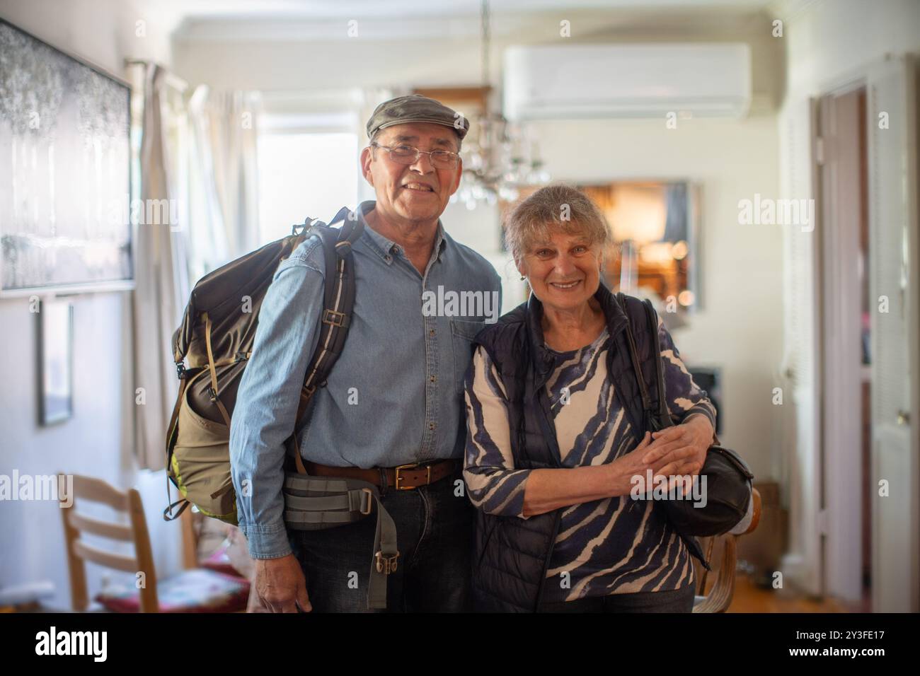Glückliches, aktives Seniorenpaar, das zu Hause steht, bereit für Urlaubsreisen Stockfoto