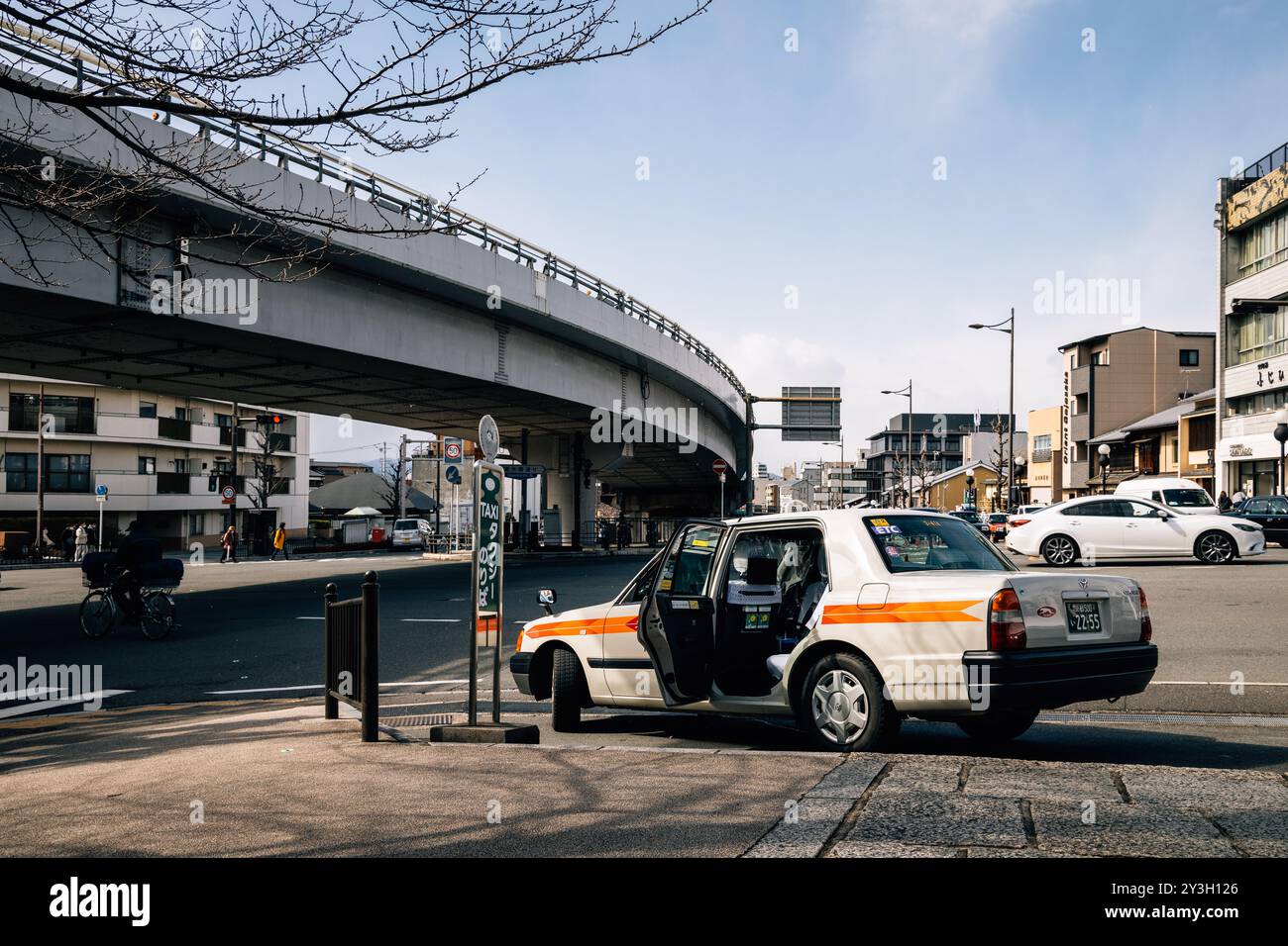 Geparktes weißes japanisches Taxi mit orangefarbenem Streifen und offener Tür | Kyoto, Japan 2023 Stockfoto