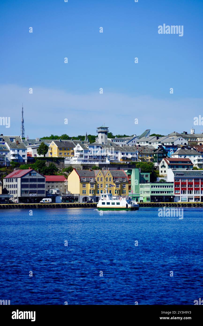 Ein malerischer Blick auf den Hafen von Torshavn auf den Färöer Inseln mit farbenfrohen Gebäuden und einem Boot an einem klaren, sonnigen Tag. Stockfoto