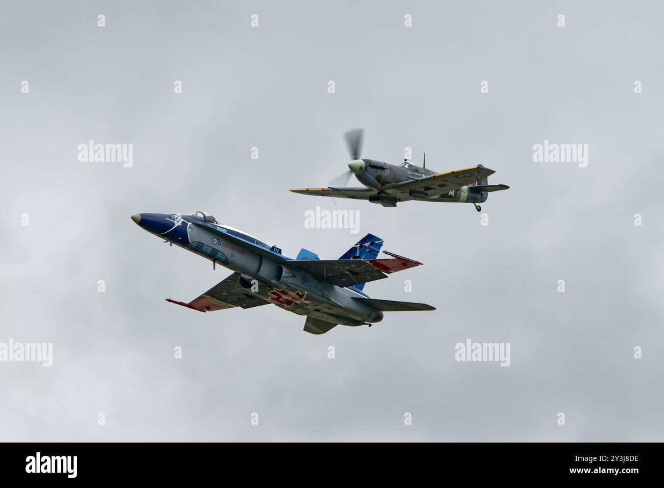 Die Royal Canadian Air Force CF-188 Hornet 774 der 425 Tactical Fighter Squadron fliegt in Formation mit einem Supermarine Spitfire World war Two Fighter Stockfoto