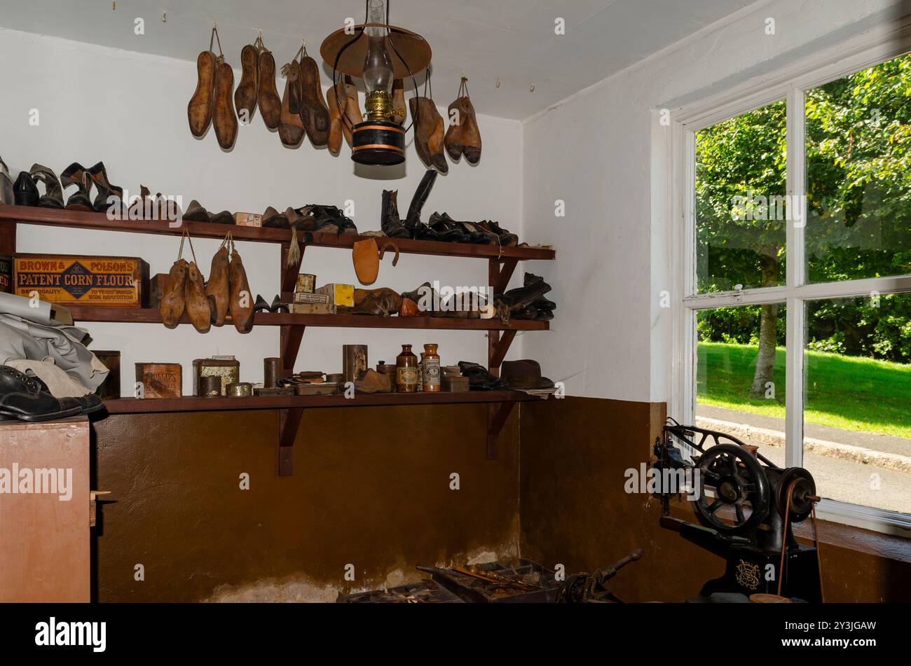 Cultra County Down Northern Ireland September 2024 - Old Cobblers Workshop mit Schuhbildnern, die von der Decke hängen und einer Nähmaschine auf einer Bank Stockfoto