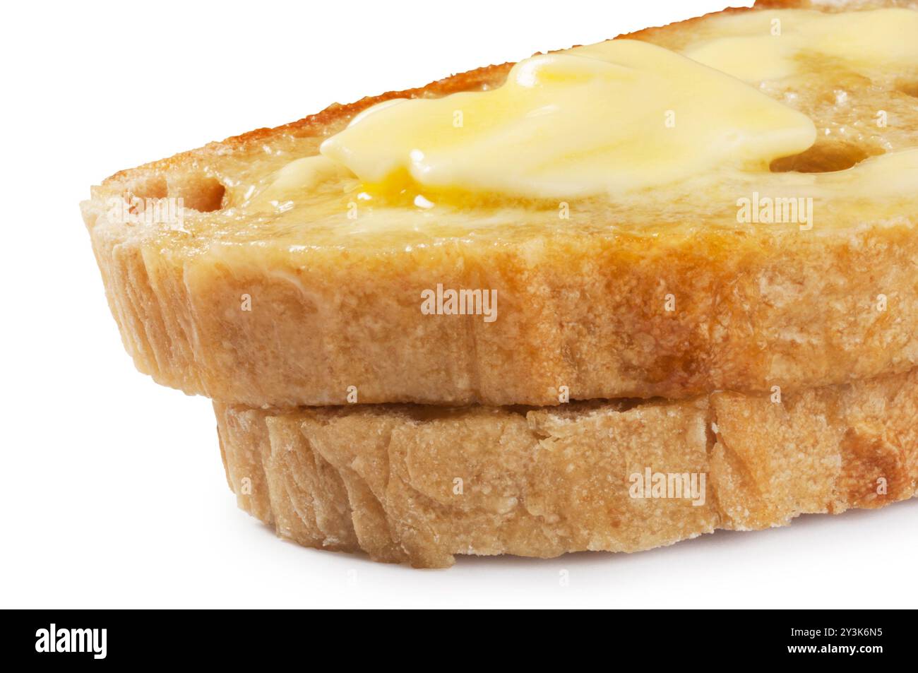 Studio-Aufnahme von Butter, die auf Scheiben Sauerteigbrot schmilzt, die vor weißem Hintergrund ausgeschnitten wurden - John Gollop Stockfoto