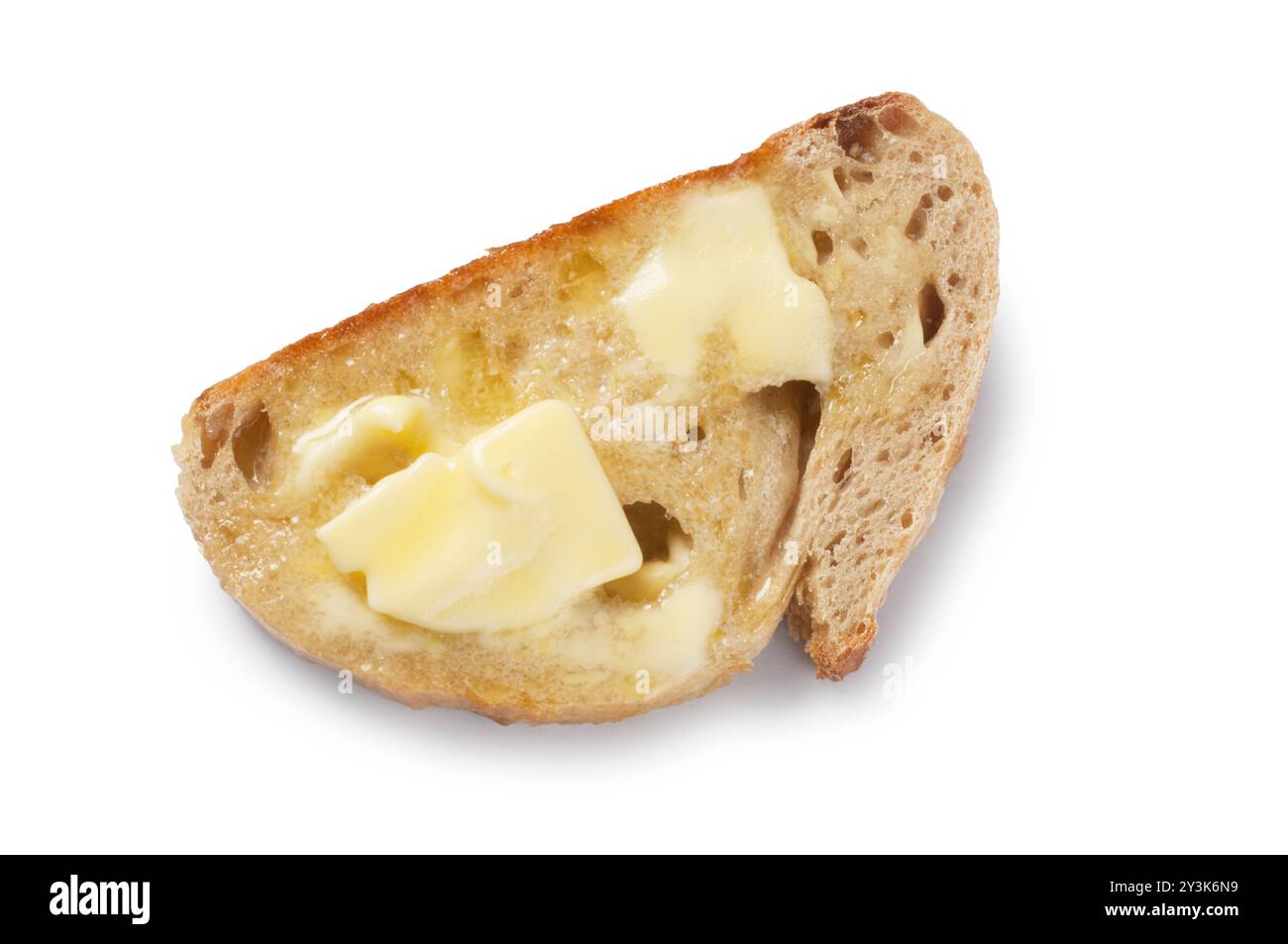 Studio-Aufnahme von Butter, die auf Scheiben Sauerteigbrot schmilzt, die vor weißem Hintergrund ausgeschnitten wurden - John Gollop Stockfoto