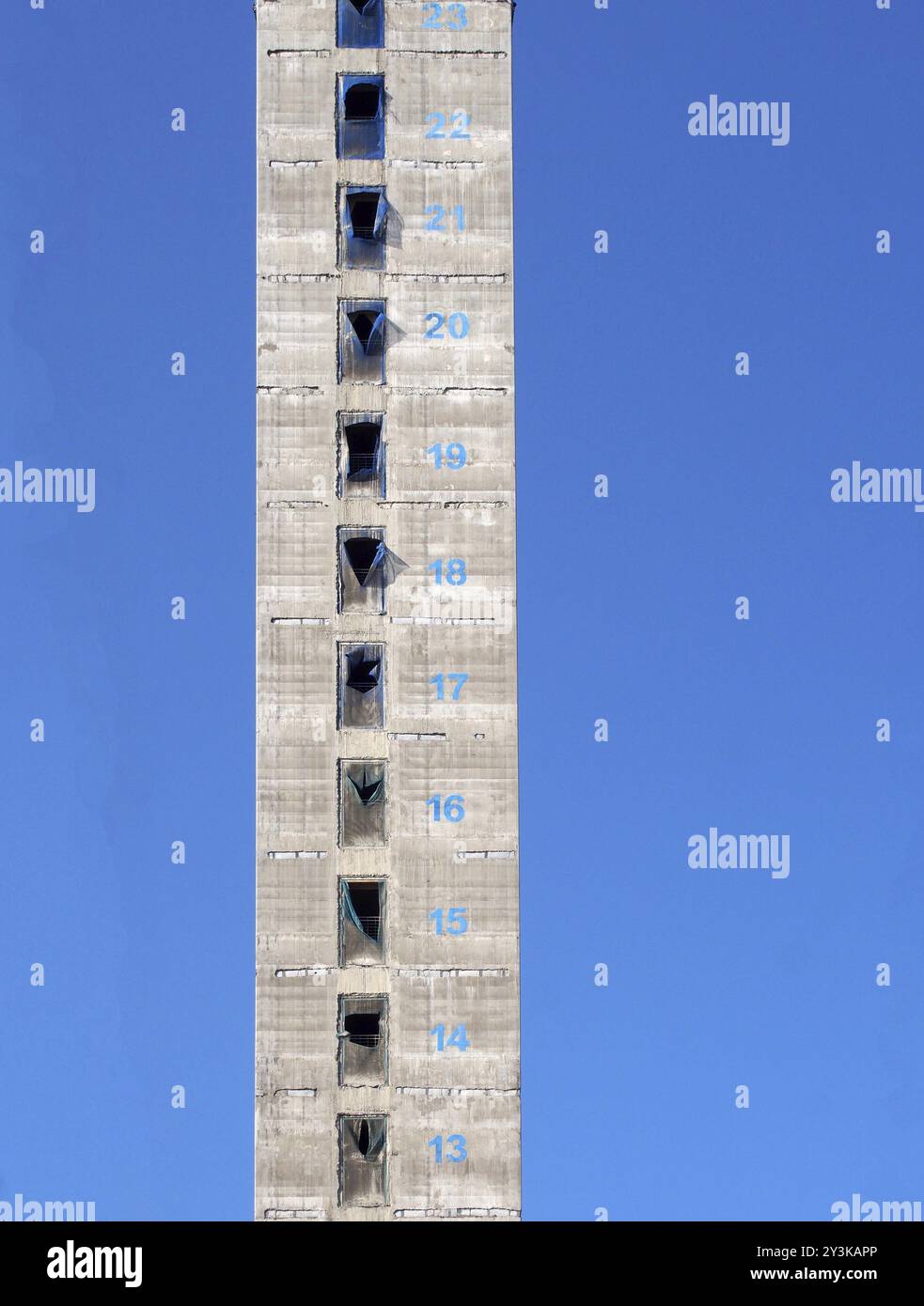 Eine hohe Betonkonstruktion und ein Servicekern eines neuen Wolkenkratzergebäudes im Bau, dessen Nummern in Farbe vor einem blauen Himmel markiert sind Stockfoto