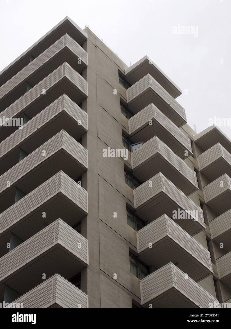 Moderner, hoher Apartmentblock aus weißem Beton mit geometrischen, eckigen Balkonen Stockfoto