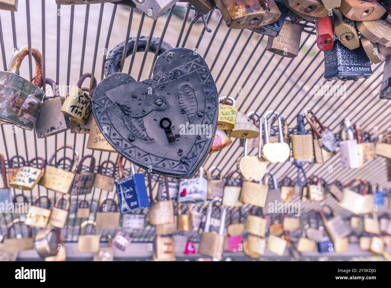 Nahaufnahme mit einem alten Metallschloss in Herzform, gefangen auf einem Zaun. Geeignet für ein Liebeskonzept oder Hintergrund Stockfoto