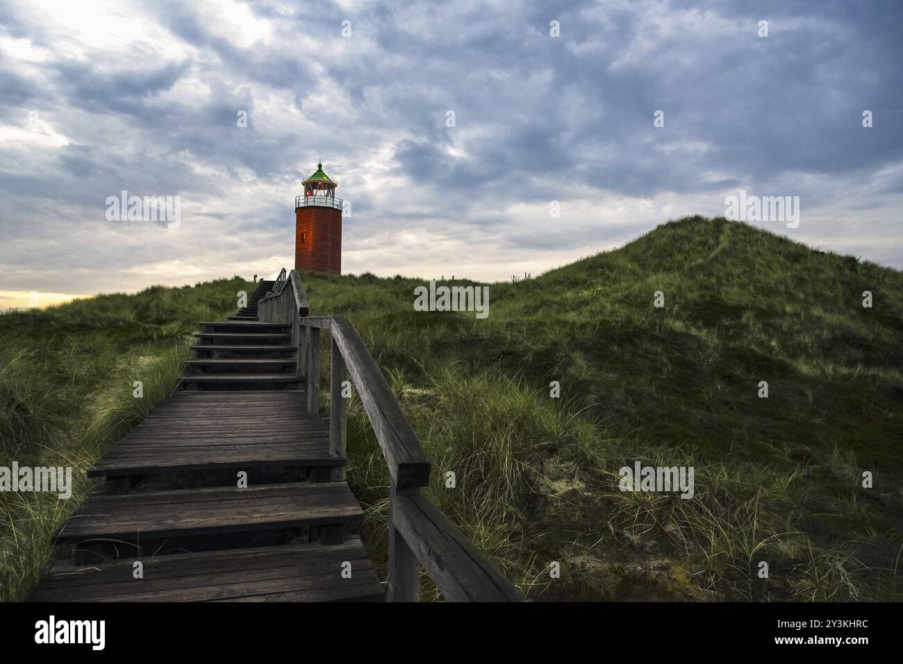 Abendliche Landschaft mit Holztreppen über Marram Grashügel, zum roten Leuchtturm, auf Sylt Insel, Deutschland, Europa Stockfoto