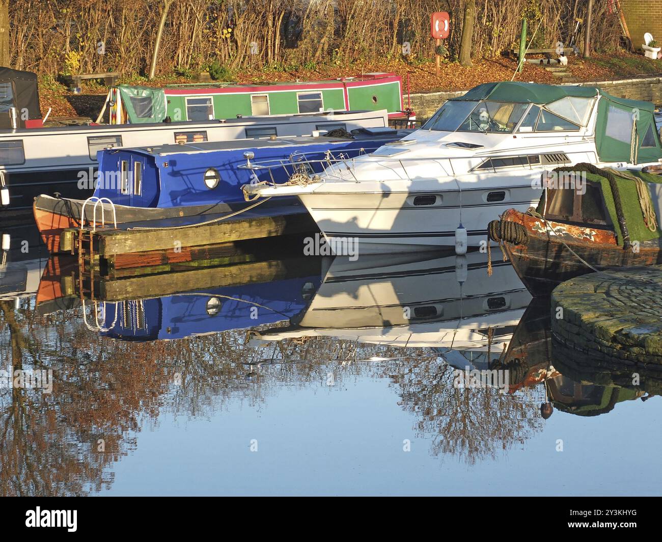 Alte schmale Boote, die zu Hausbooten umgebaut wurden, liegen im Yachthafen im brighouse Basin in West yorkshire Stockfoto