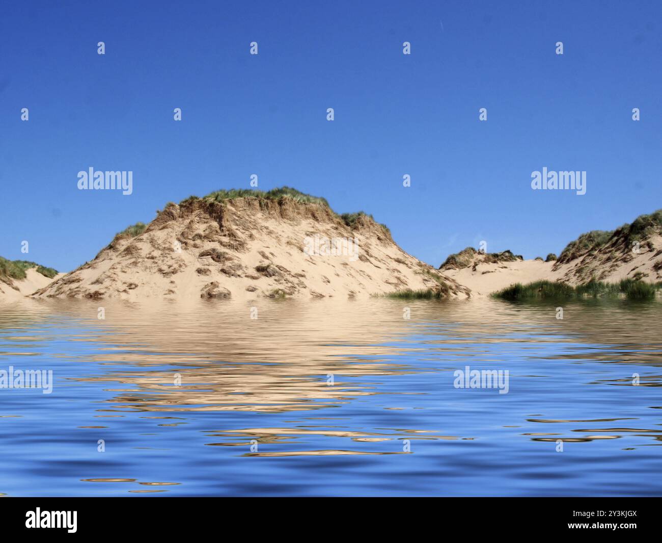 Der Strand vom Meer aus in formby merseyside mit hohen Sanddünen, die mit rauem Gras bedeckt sind, und einem blauen sonnigen Sommerhimmel Stockfoto