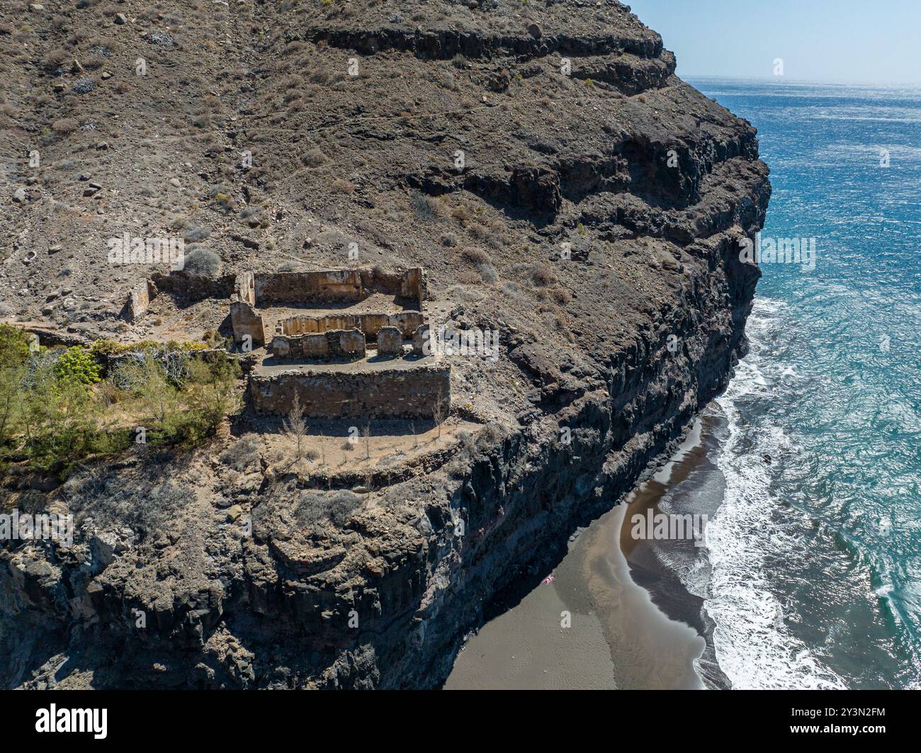 Aus der Vogelperspektive auf eine Ruine über dem GUI GUI Strand, unberührter schwarzer Sandstrand, Gran Canaria. Spanien. Panoramaweg Stockfoto