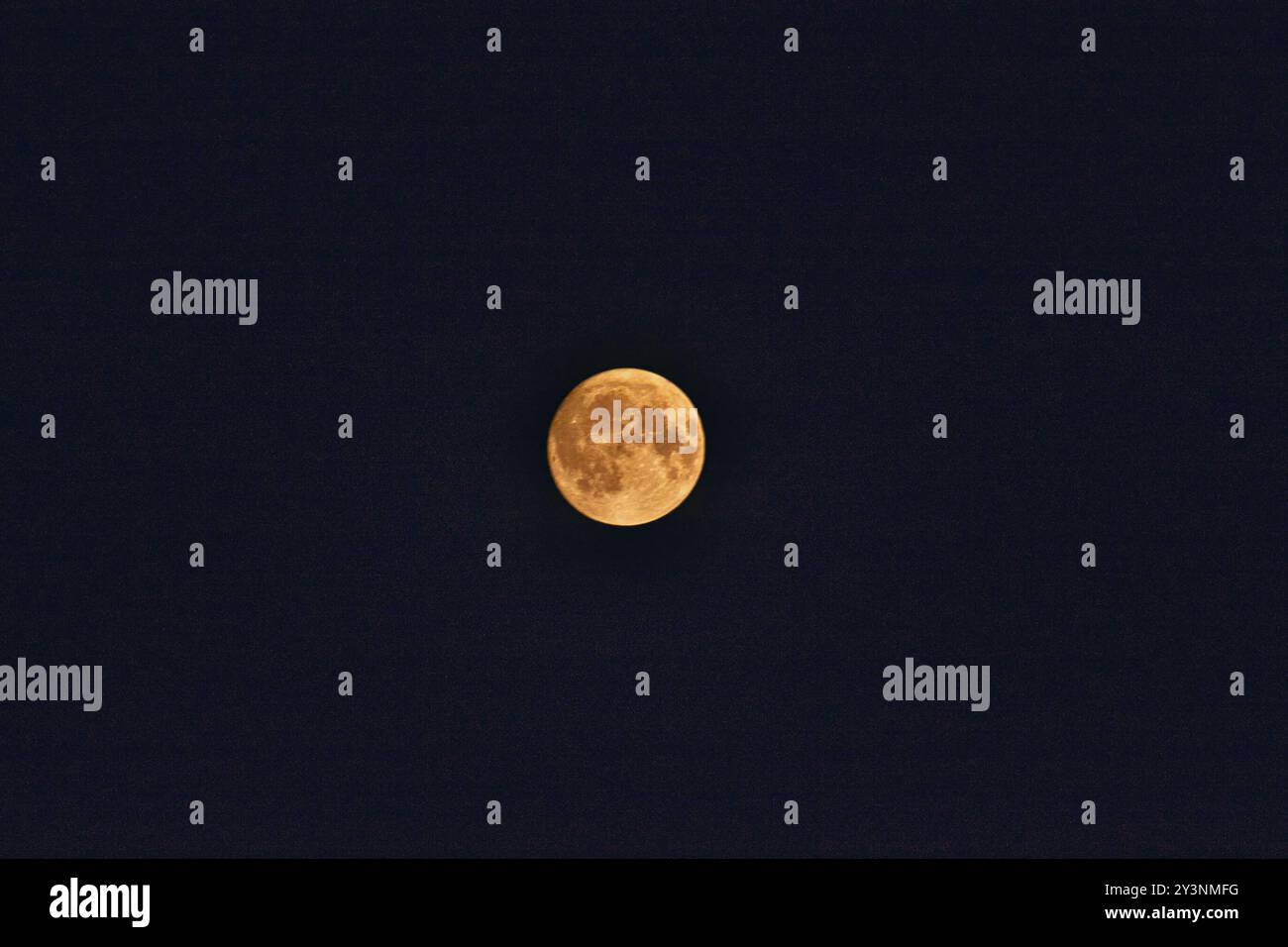 Ein heller Vollmond, der in einem dunklen Nachthimmel leuchtet und seine Krater und Oberflächendetails zeigt. Stockfoto