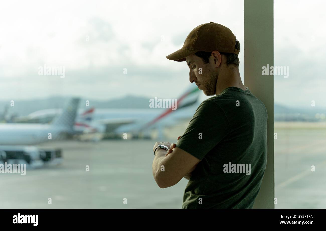Reisender Mann, der auf das Flugzeug am Flughafen wartet Stockfoto
