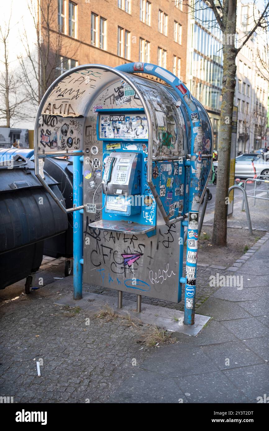 Öffentliche Telefonzelle mit Aufklebern und Graffitt in Berlin Deutschland Stockfoto