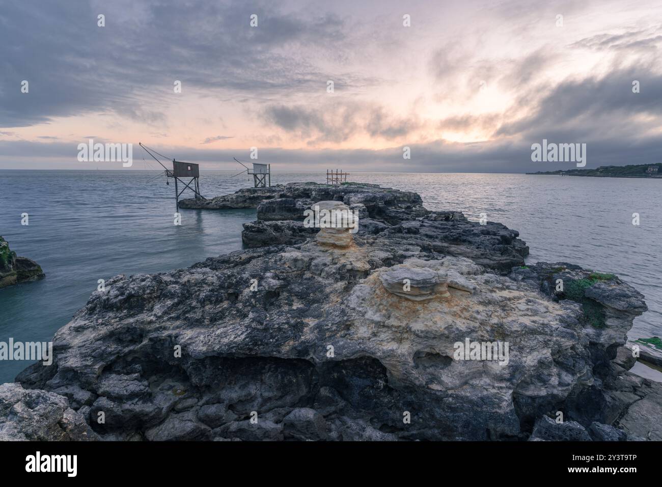 Sonnenuntergang entlang der Küste mit traditionellen Carrelets in Charente-Maritime in Frankreich Stockfoto