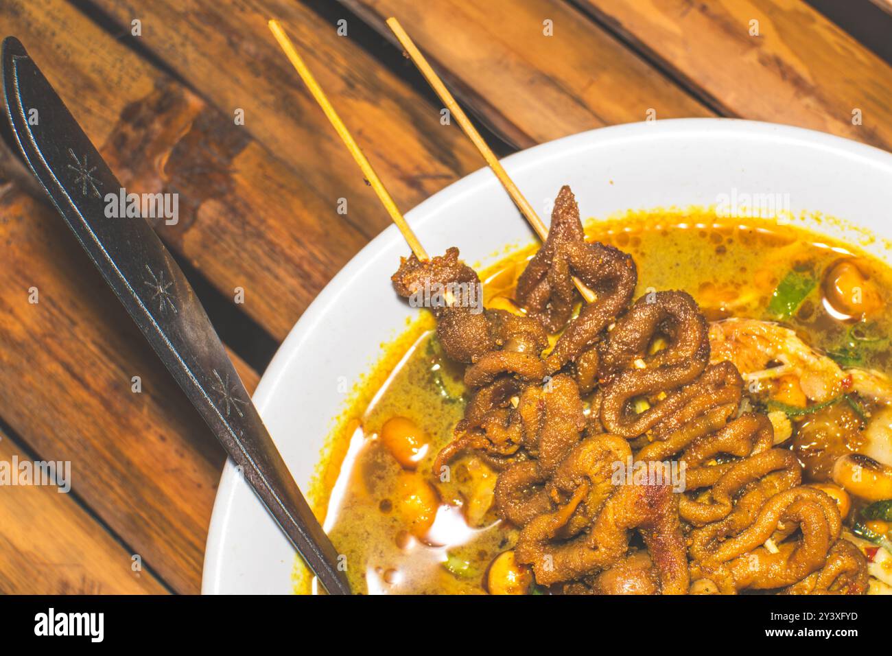 Hähnchenbrei Schüssel serviert mit einzigartigen Gerichten. Traditioneller Hähnchenbrei mit Hähnchendarm-Satay-Gerichten, authentisch traditionell aus Indonesisch Stockfoto