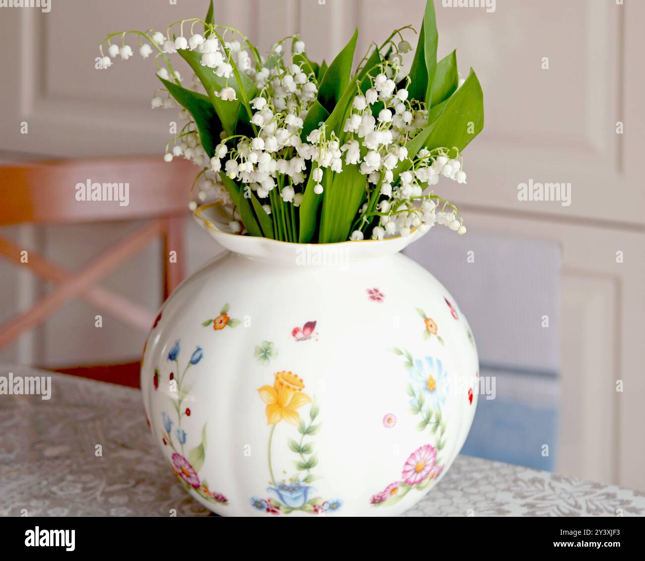 Blumenstrauß von Maiglöckchen in weißer Vase drinnen auf dem Tisch. Frühlingsblumen und Stimmung, Lebensstil. Stockfoto
