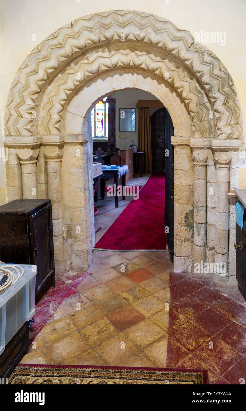 Chevron-Zickzackmuster eines normannischen Bogengangs in der Kirche Saint Peter, Theberton, Suffolk, England, Großbritannien Stockfoto