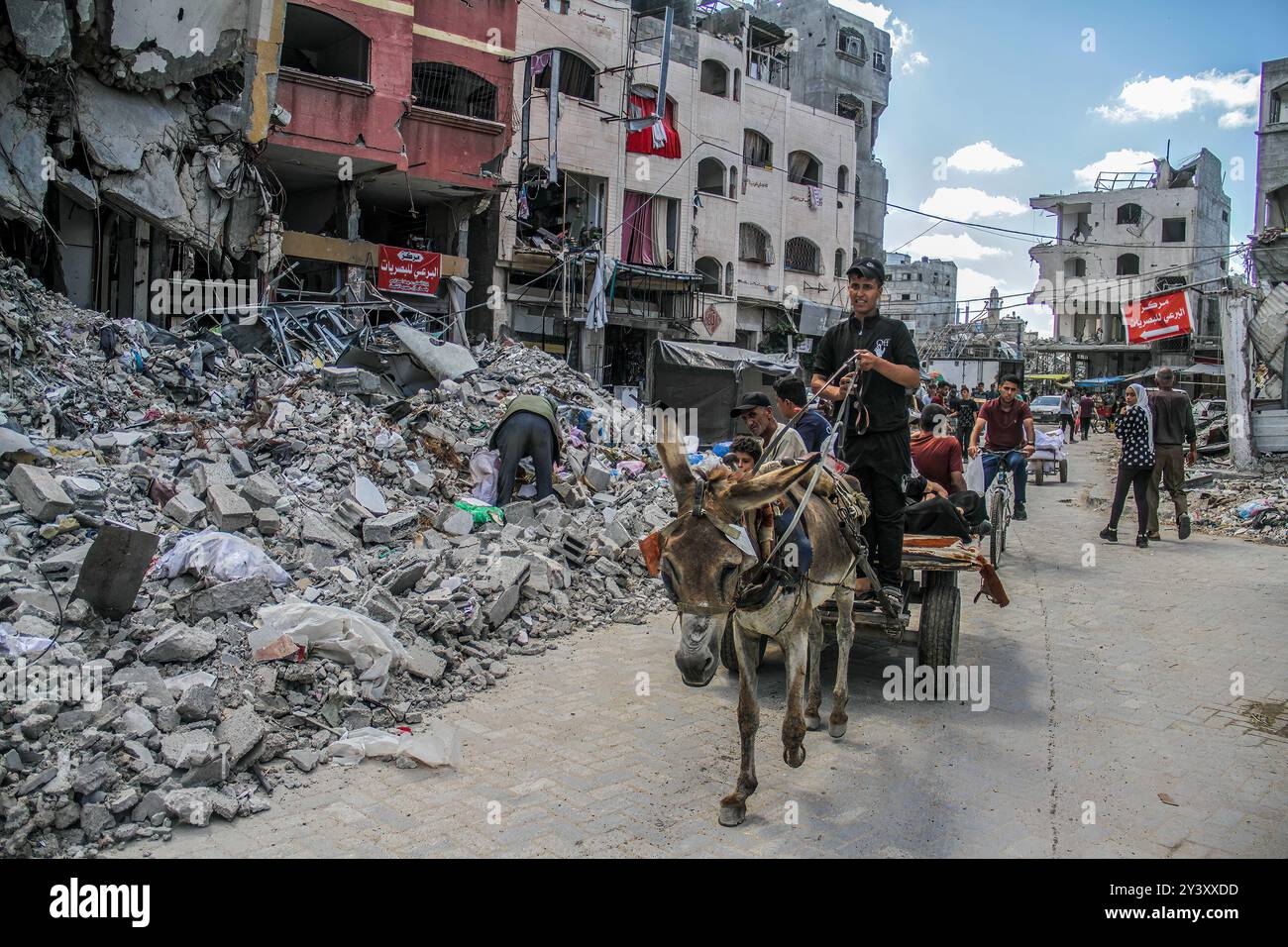 Die Palästinenser ziehen am beschädigten Al-Aliya Kindergarten vorbei, nachdem er von einem israelischen Flugzeug im Lager Jabalia nördlich von Gaza bombardiert wurde. Der Gaza-Konflikt, der im Oktober 2023 wieder ausgebrochen war, begann mit einem überraschenden Angriff der Hamas auf israelische Städte, der zu Massensursachen und zur Entführung von Zivilisten führte. Als Reaktion darauf startete Israel schwere Luftangriffe und eine Bodenoffensive in Gaza. Die Kämpfe haben auf beiden Seiten Tausende von Toten gefordert, wobei Gaza aufgrund blockierter Hilfe und Infrastrukturschäden mit schweren humanitären Krisen konfrontiert ist. Der Konflikt hat die internationale Aufmerksamkeit mit Aufrufen zum Waffenstillstand auf sich gezogen Stockfoto