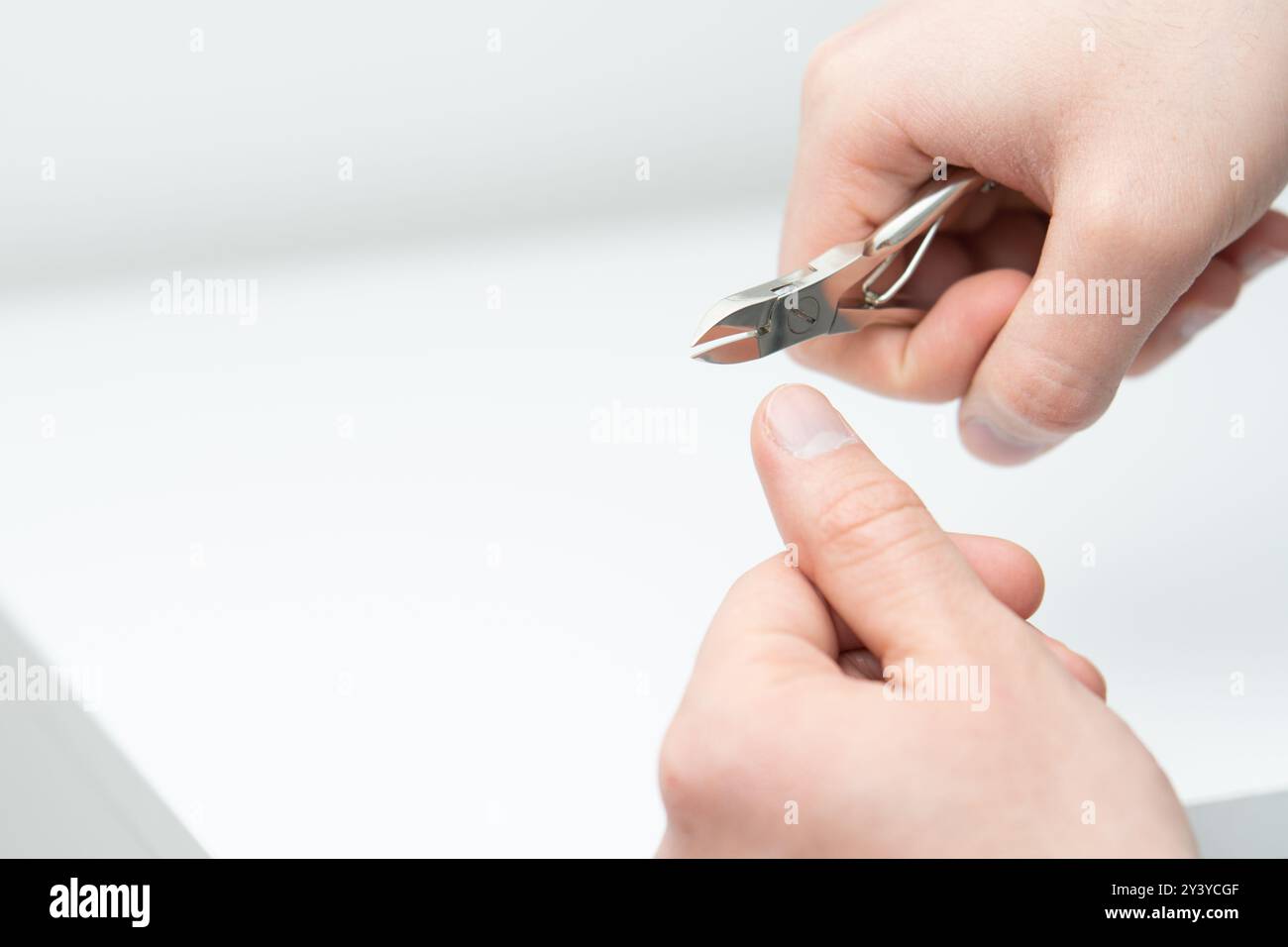 Männliche Hand für zwei Arten von Nagelschneider-Zangen und zusammengesetzten Hebeln Stockfoto