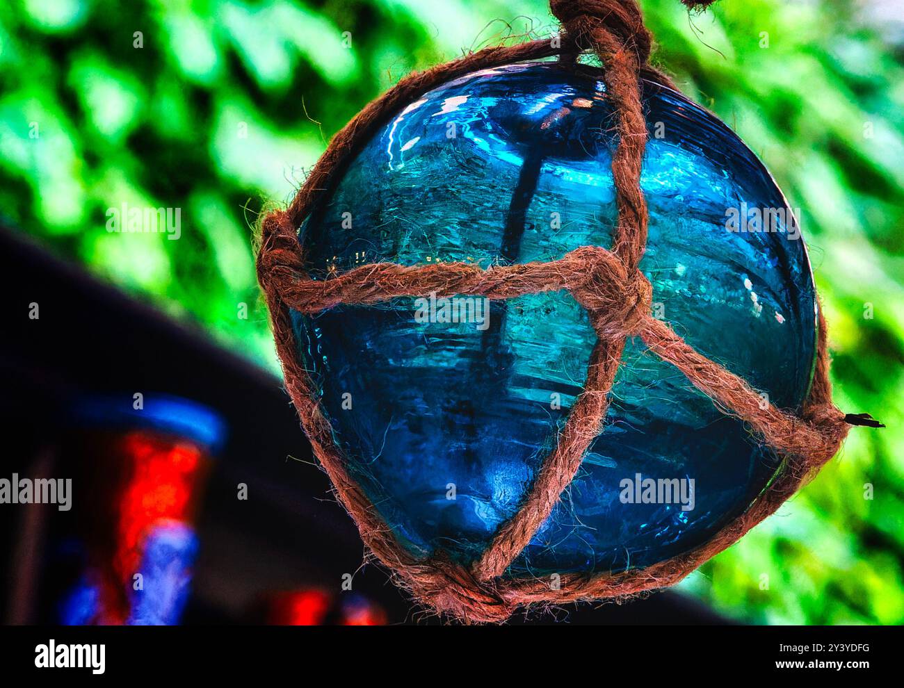 Eine blaue Glaskugel in einem Seilnest Stockfoto