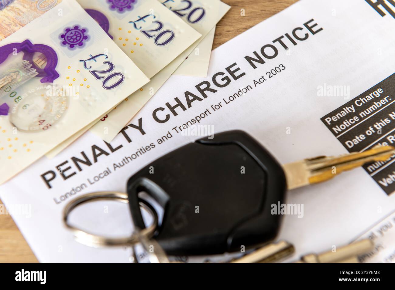 Nahaufnahme eines Bußgeldbescheids mit Autoschlüsseln und Banknoten. Stockfoto