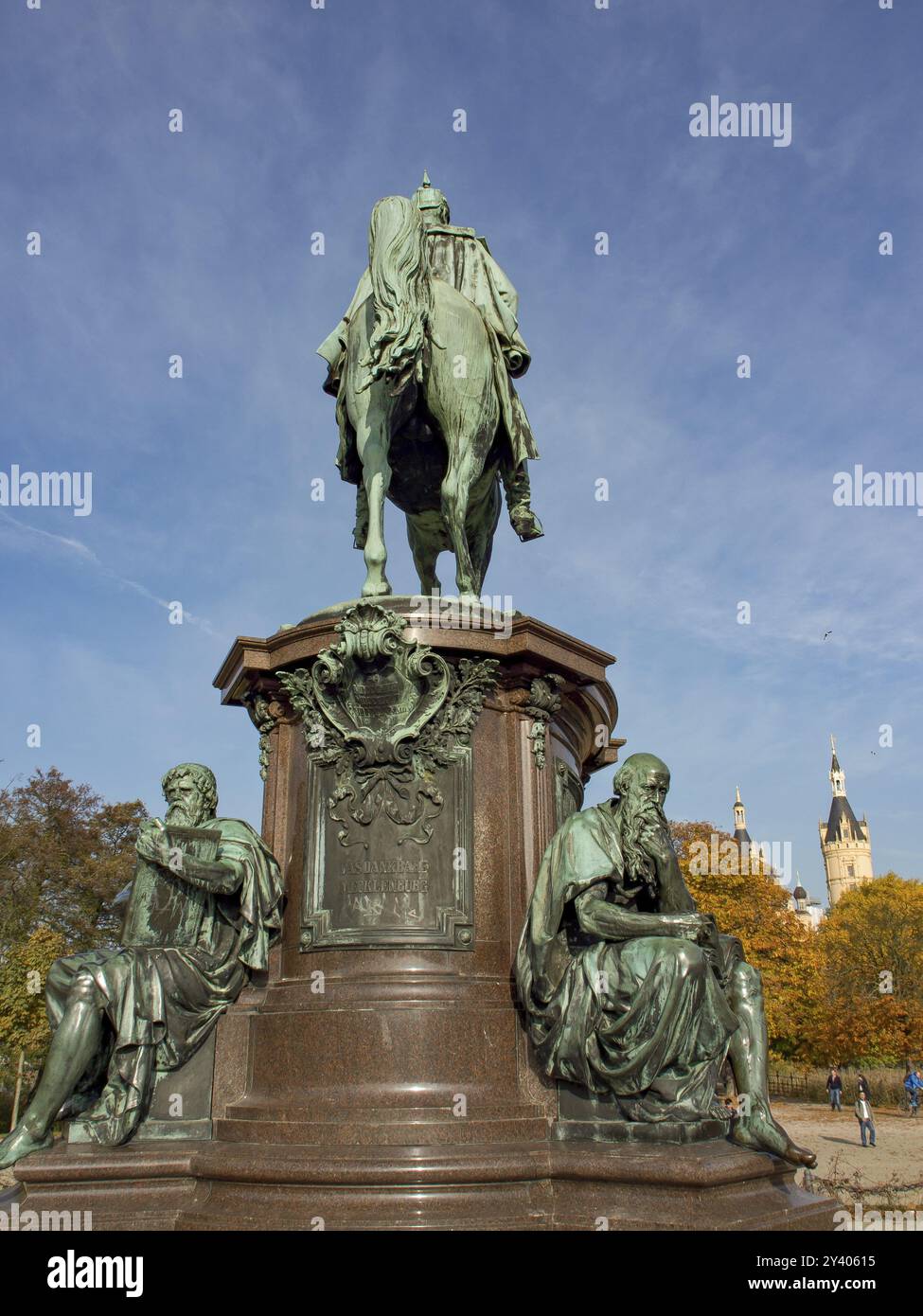 Reiterdenkmal flankiert von zwei sitzenden Statuen vor herbstlichen Bäumen und blauem Himmel, Schwerin, Mecklenburg, Deutschland, Europa Stockfoto