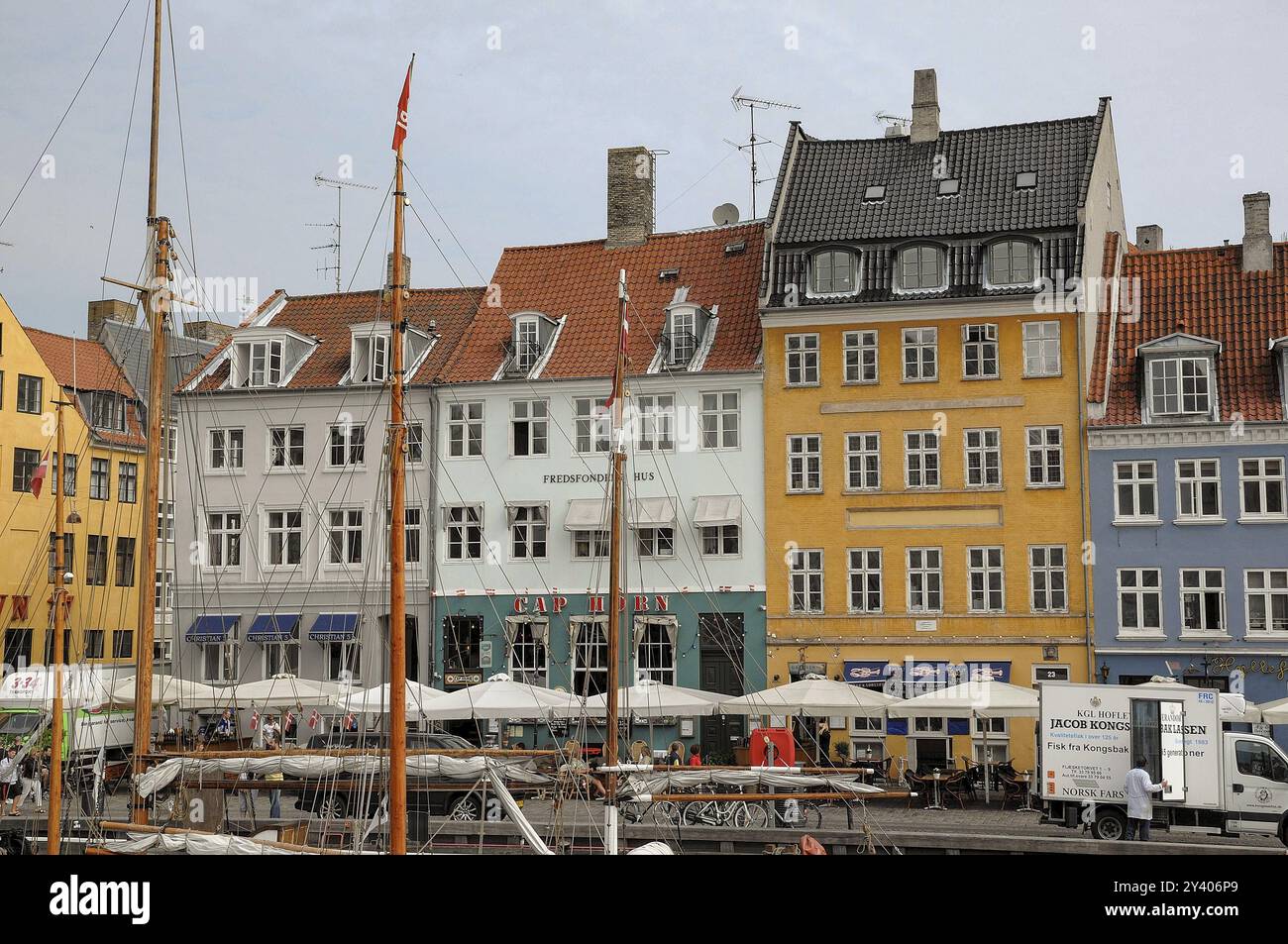 Historische, farbenfrohe Häuser am Kanal mit Segelbooten und Menschen in Straßencafés in kopenhagen, dänemark Stockfoto