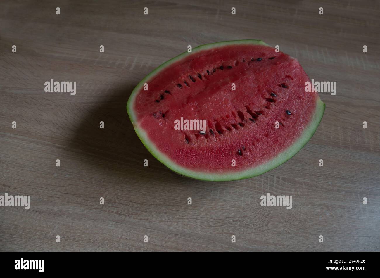 Teil einer Reifen großen Wassermelone mit schöner grüner Haut und saftigem, innerem Fruchtfleisch, die auf einem Tisch platziert wurde, Sofia, Bulgarien Stockfoto