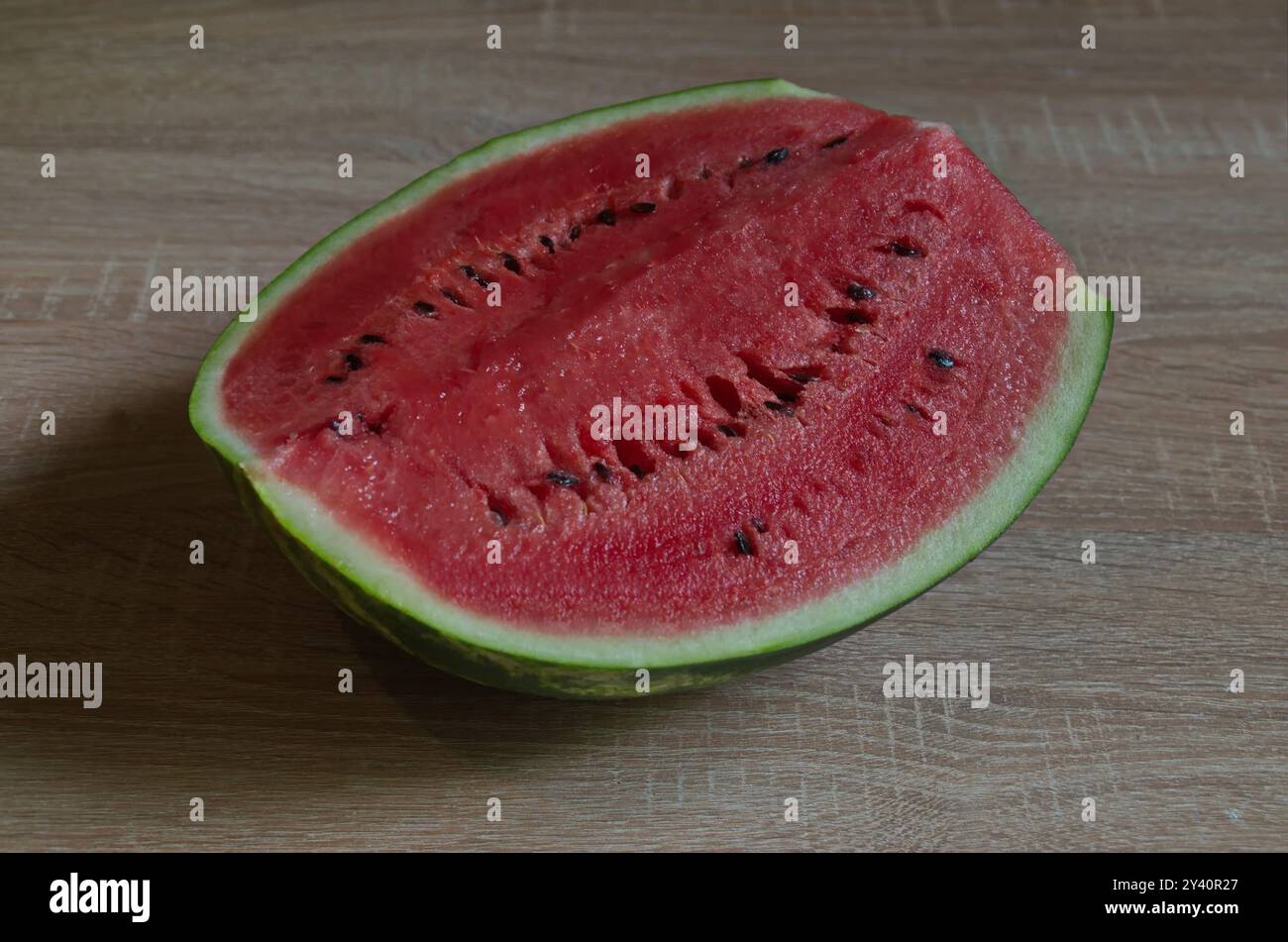Teil einer Reifen großen Wassermelone mit schöner grüner Haut und saftigem, innerem Fruchtfleisch, die auf einem Tisch platziert wurde, Sofia, Bulgarien Stockfoto
