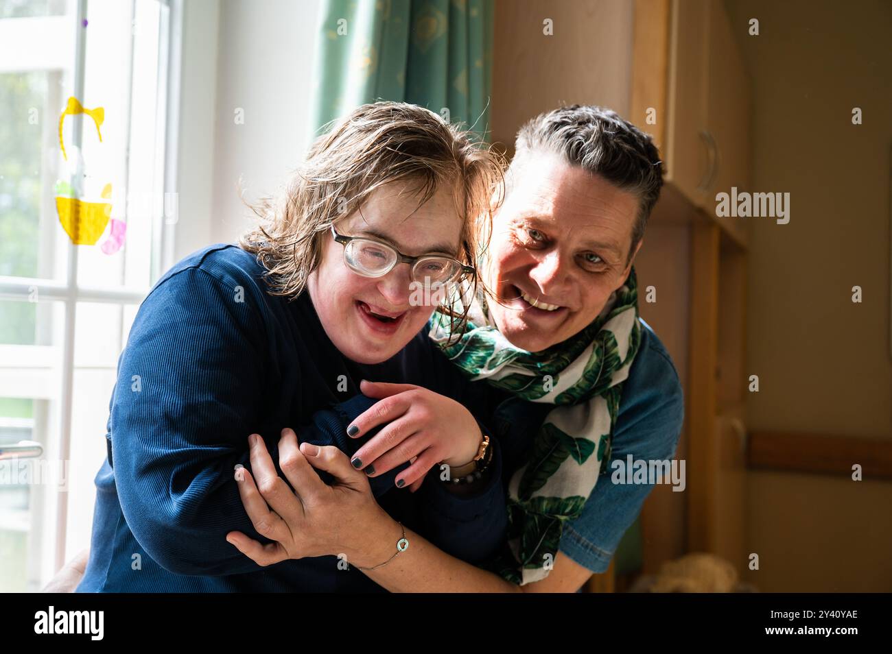 Emotionale Verbindung zwischen Down-Syndrom-Frau und beruflicher Hausmeisterin, Tienen, Flämisch-Brabant, Belgien, 20. April, 2023. teilweise Modellfreigabe Stockfoto
