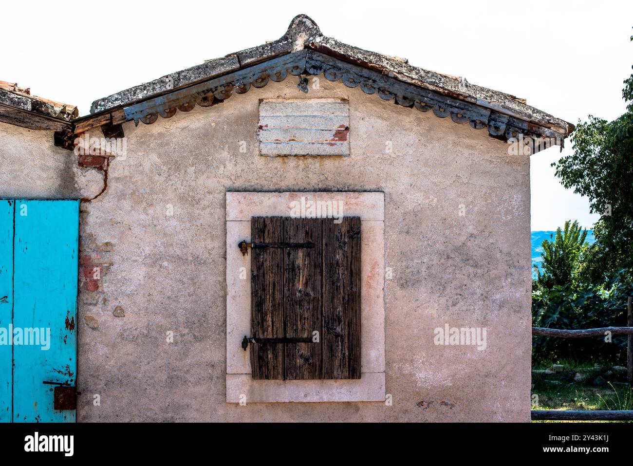 Ecke des kroatischen Dorfes zwischen blauem Himmel und Steinhäusern mit blauen Fenstern Stockfoto