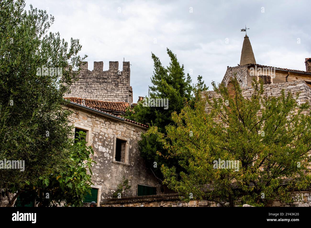 Ecke des kroatischen Dorfes zwischen blauem Himmel und Steinhäusern mit blauen Fenstern Stockfoto