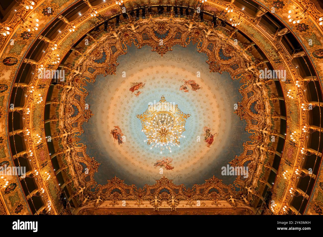 Venedig, Italien - 24. März 2024 - Innenraum des Opernhauses Teatro La Fenice, verzierte Innenausstattung im Rokoko-Stil, Blick bis zur Decke mit Gemälden und Kronleuchtern Stockfoto