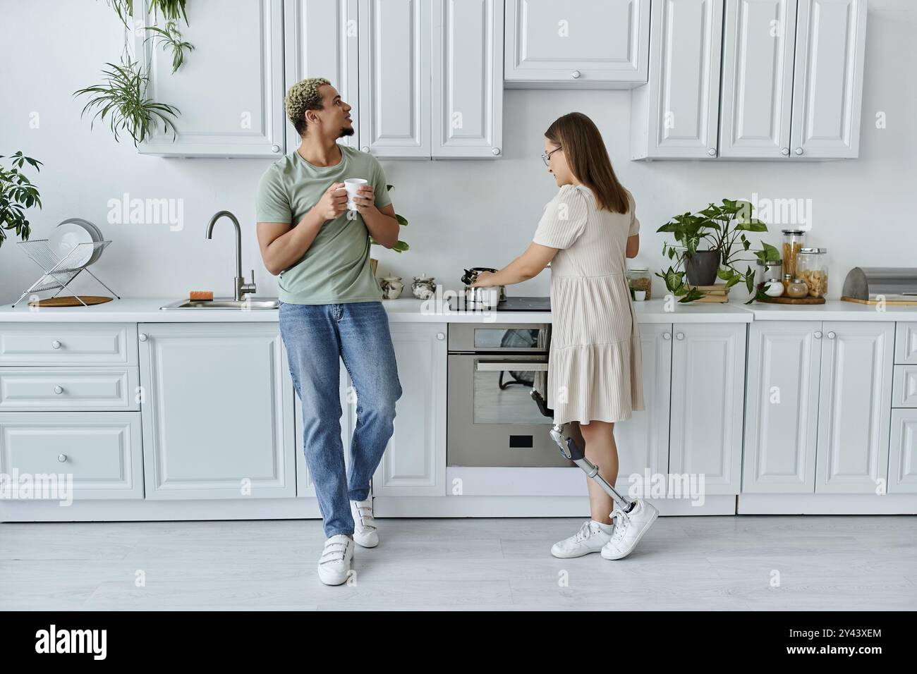 Freunde teilen einen fröhlichen Moment, während sie gemeinsam in einer gemütlichen Küche kochen. Stockfoto