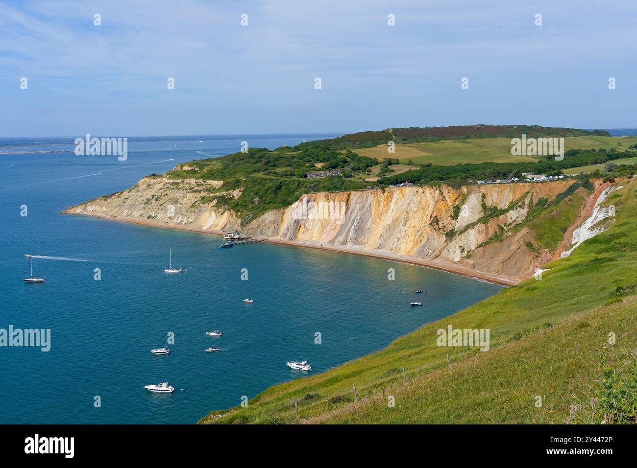 Auf den Klippen der Alum Bay mit Blick auf den Strand und die Boote, die im ruhigen Wasser verankert sind. Stockfoto