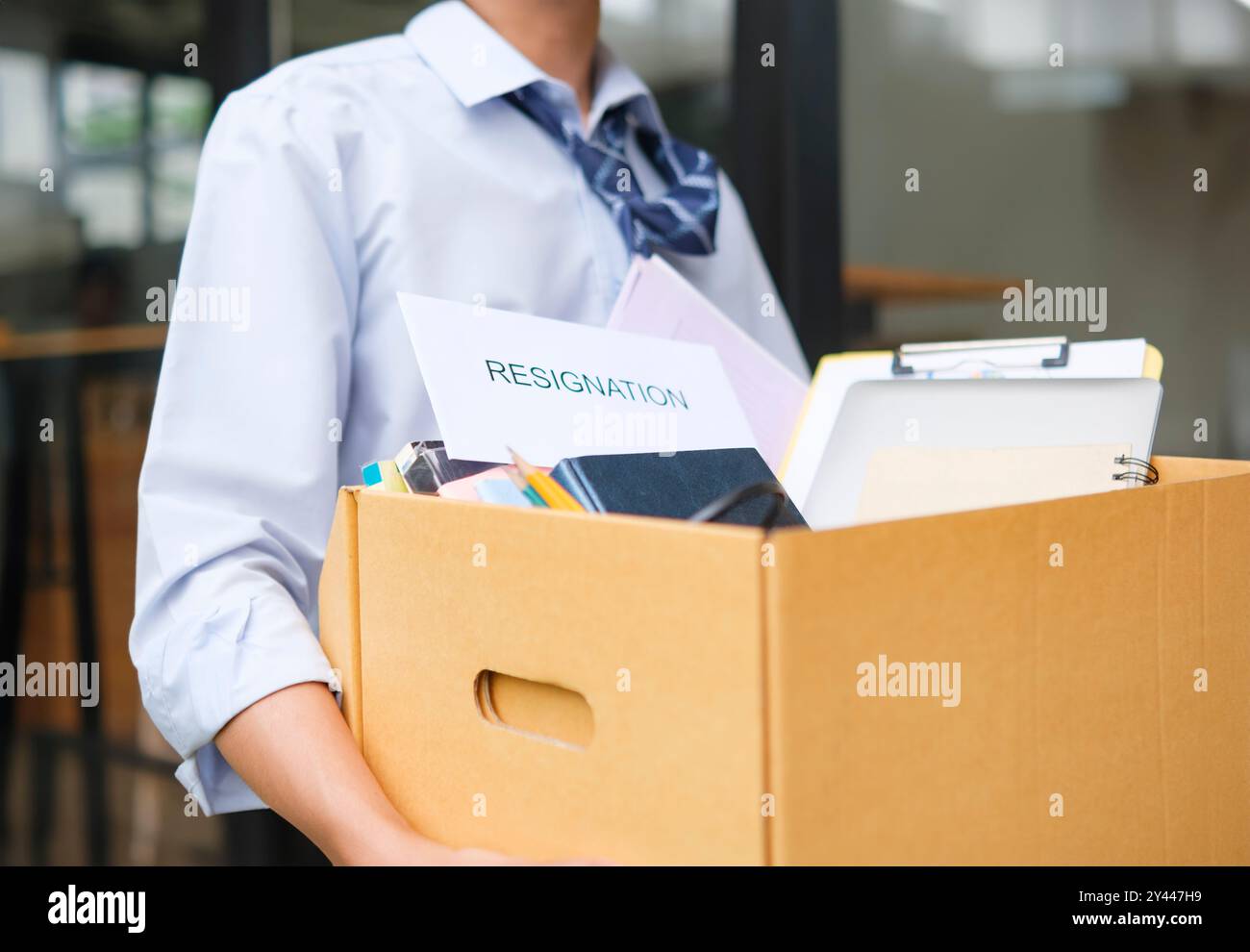 Geschäftsmann verlässt sein Amt nach seinem Rücktritt mit Box voller Sachen Stockfoto
