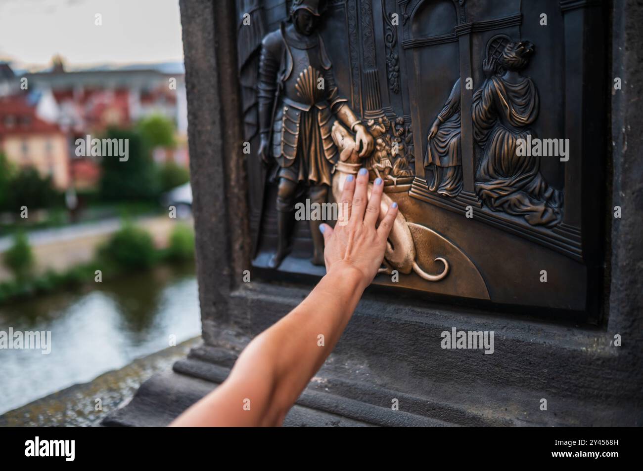 Touristen berühren eine Gedenktafel, die Teil der Statue des Heiligen Johannes von Nepomuk ist, für viel Glück, Prag. Stockfoto