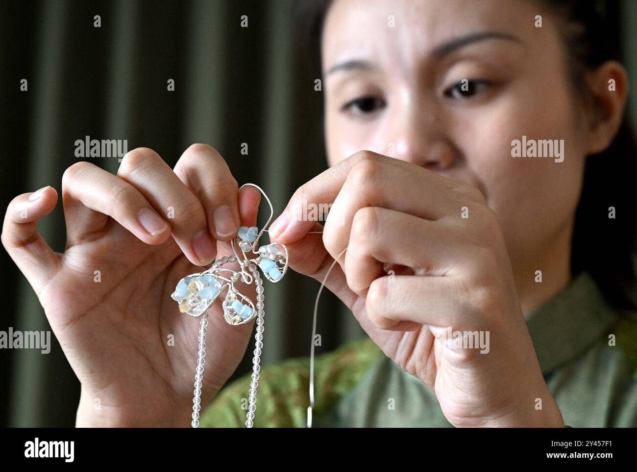 (240916) -- LUOYANG, 16. September 2024 (Xinhua) -- Chu Mengdan fertigt Kunsthandwerk für Perlenweben in einer Erlebnishalle des immateriellen Kulturerbes in der Stadt Luoyang, Zentralchinas Provinz Henan, 12. September 2024. Chu Mengdan ist der Erben der vierten Generation von Bead Weaving Skills, einem Projekt des immateriellen Kulturerbes im Bezirk Chanhe in Luoyang. Die Kunst, Perlen so klein wie Reiskörner zu nähten und zu einzigartigen Mustern oder Formen zu verbinden, wird als Perlenweben bezeichnet, das in Kleidung und Schmuck verwendet wird. Der Herstellungsprozess der exquisiten Handwerkskunst mit Perlen ist viel komplizierter als er ist Stockfoto