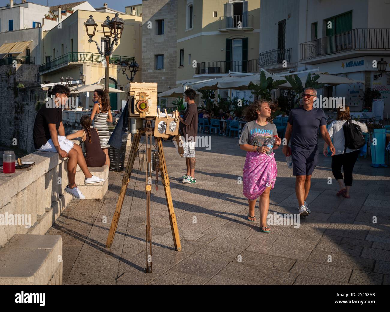 Touristen spazieren vorbei an einer Pix in a Box großformatigen Holzplatten-Kamera mit Vintage-Stil Schwarz-weiß-Foto-Souvenirs, Otranto, Apulien, Italien. Stockfoto